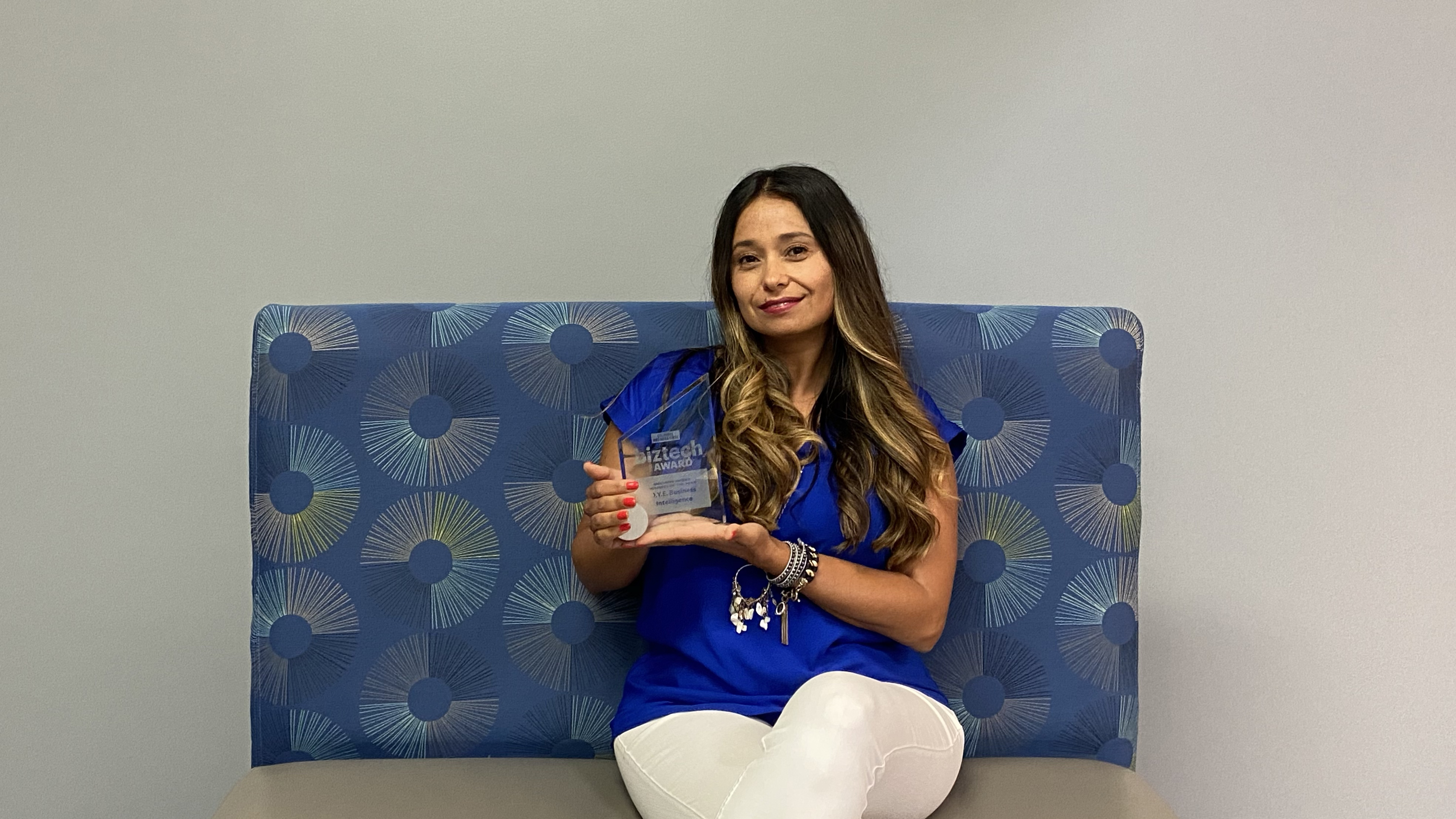 Natasha holding her 2020 Minority-Owned Business of the Year award.